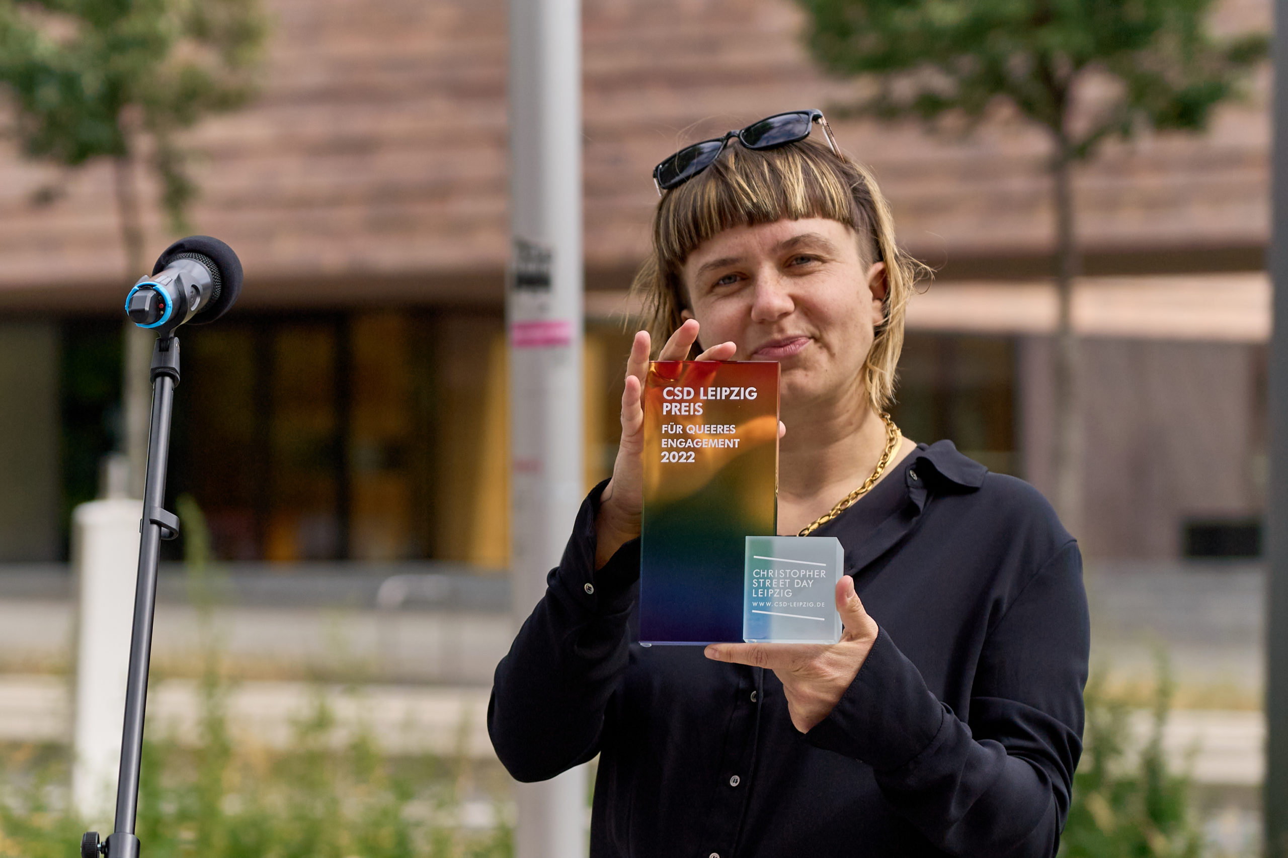 Luise Herrmann nimmt den CSD Leipzig Preis stellvertretend für das QRN entgegen