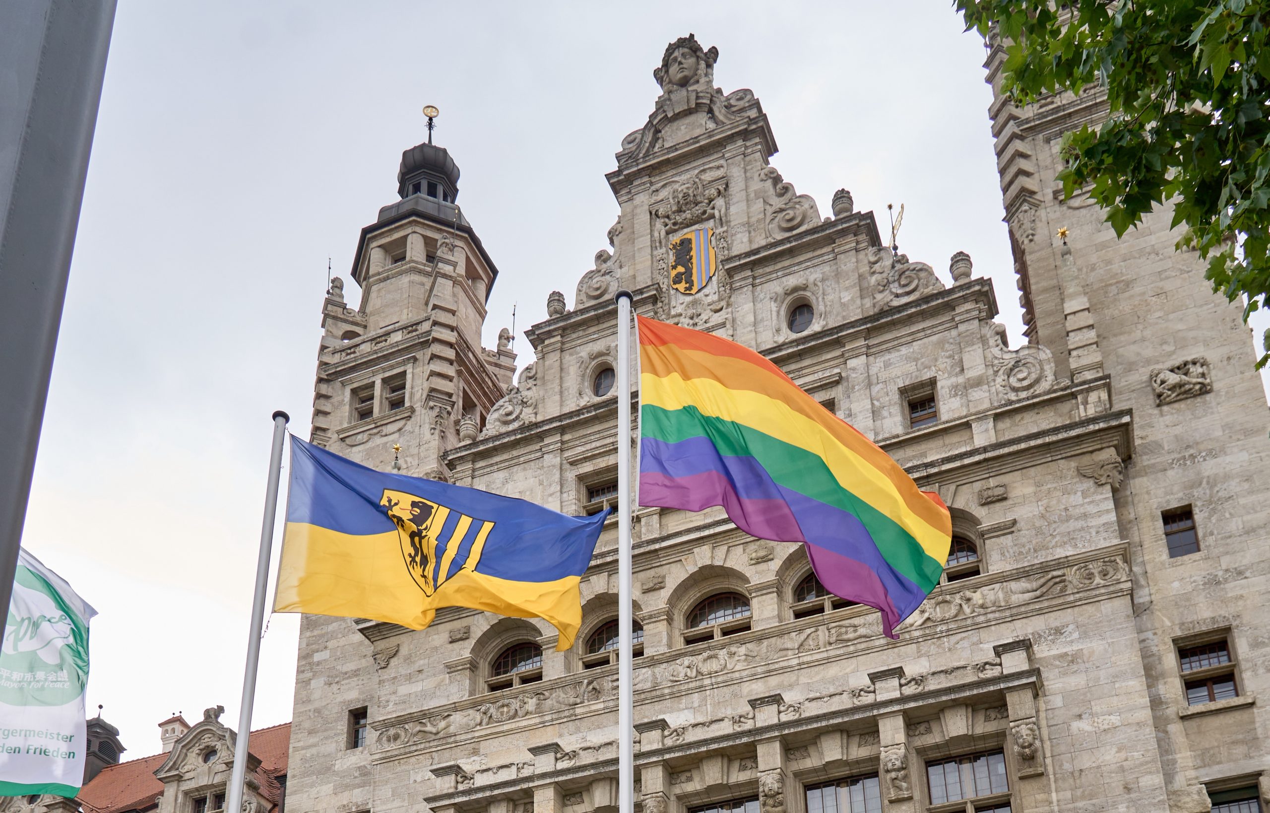 Vor dem Neuen Rathaus weht die Regenbogenflagge neben der Flagge der Stadt Leipzig