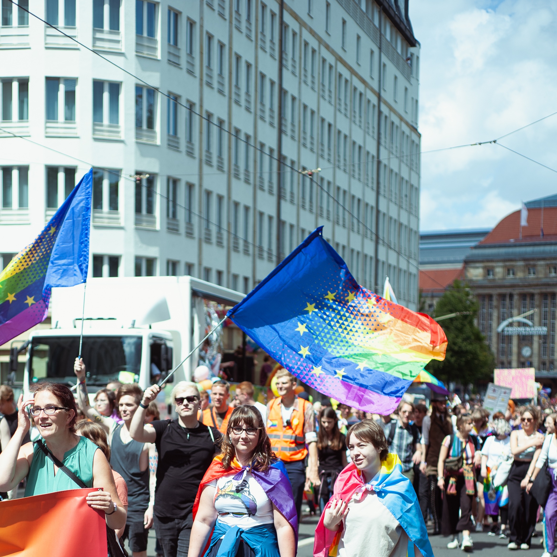 Bei der CSD-Demo werden regenbogenfarbene EU-Flaggen geschwenkt.