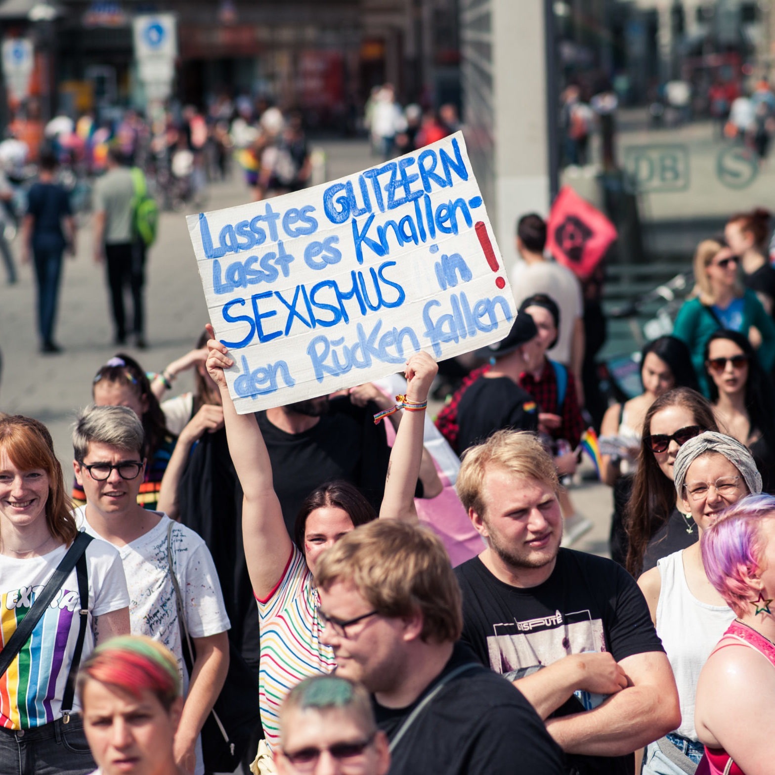 Demo-Schild mit der Aufschrift "Lasst es glitzern lasst es knallen - Sexismus in den Rücken fallen!"
